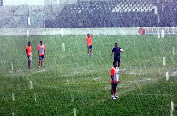 Jogadores treinam em baixo de chuva
